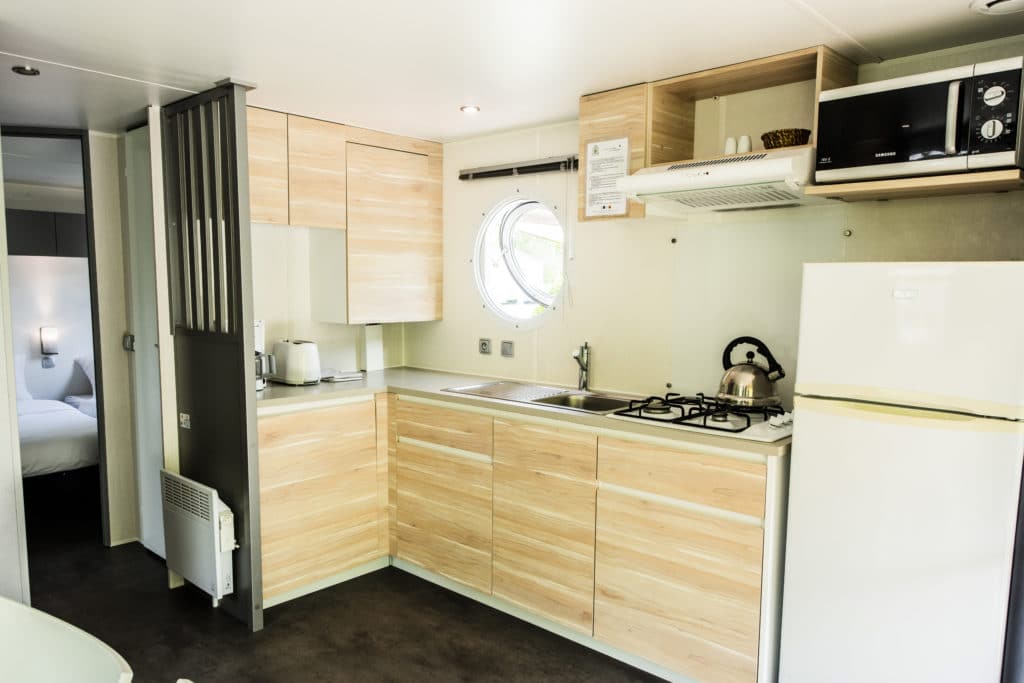 Cuisine moderne équipée avec réfrigérateur et micro-ondes.