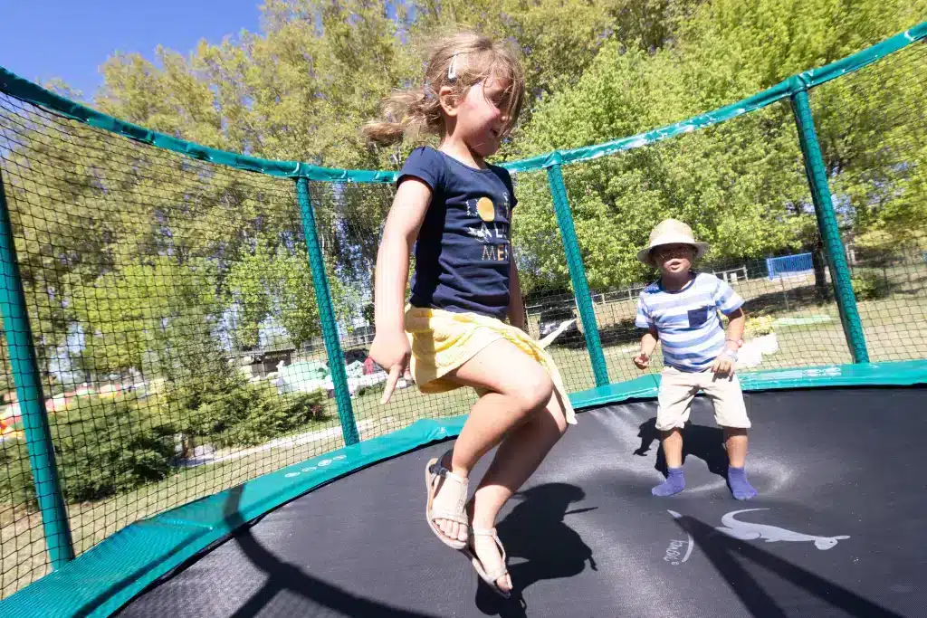 Enfants sautant sur trampoline sur l'aire de jeux