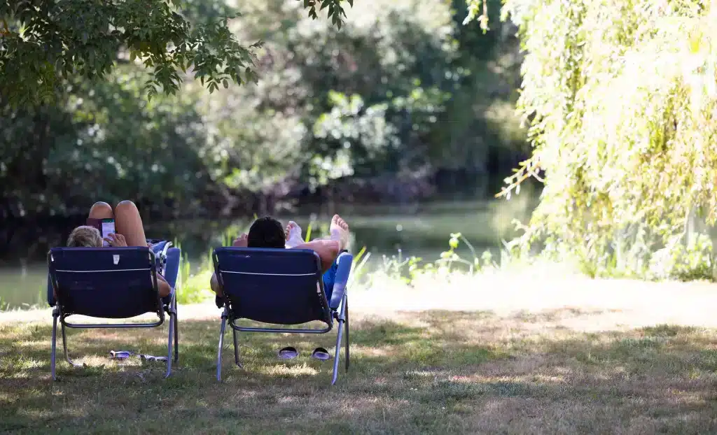 Deux personnes dans des chaises longues au bord d'un lac