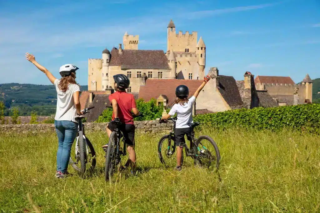 Cyclistes regardant château historique en plein air.