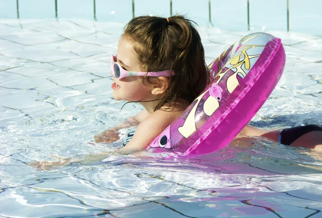 Parents surveillant leurs enfants qui s’éclaboussent dans la pataugeoire du Camping La Dordogne Verte, un espace aquatique adapté aux tout-petits